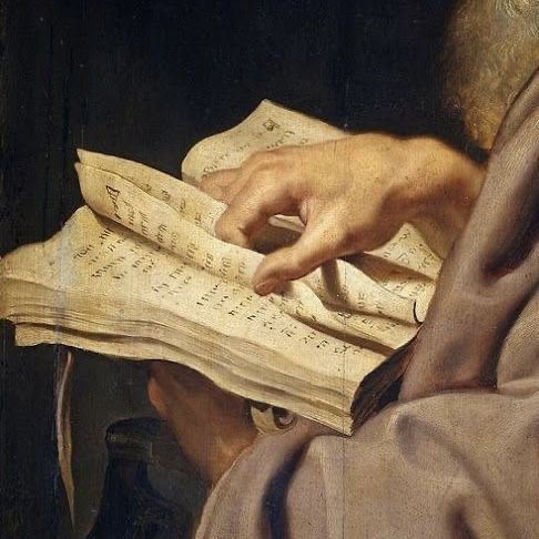 A hand turning the page of an antique leather-bound manuscript